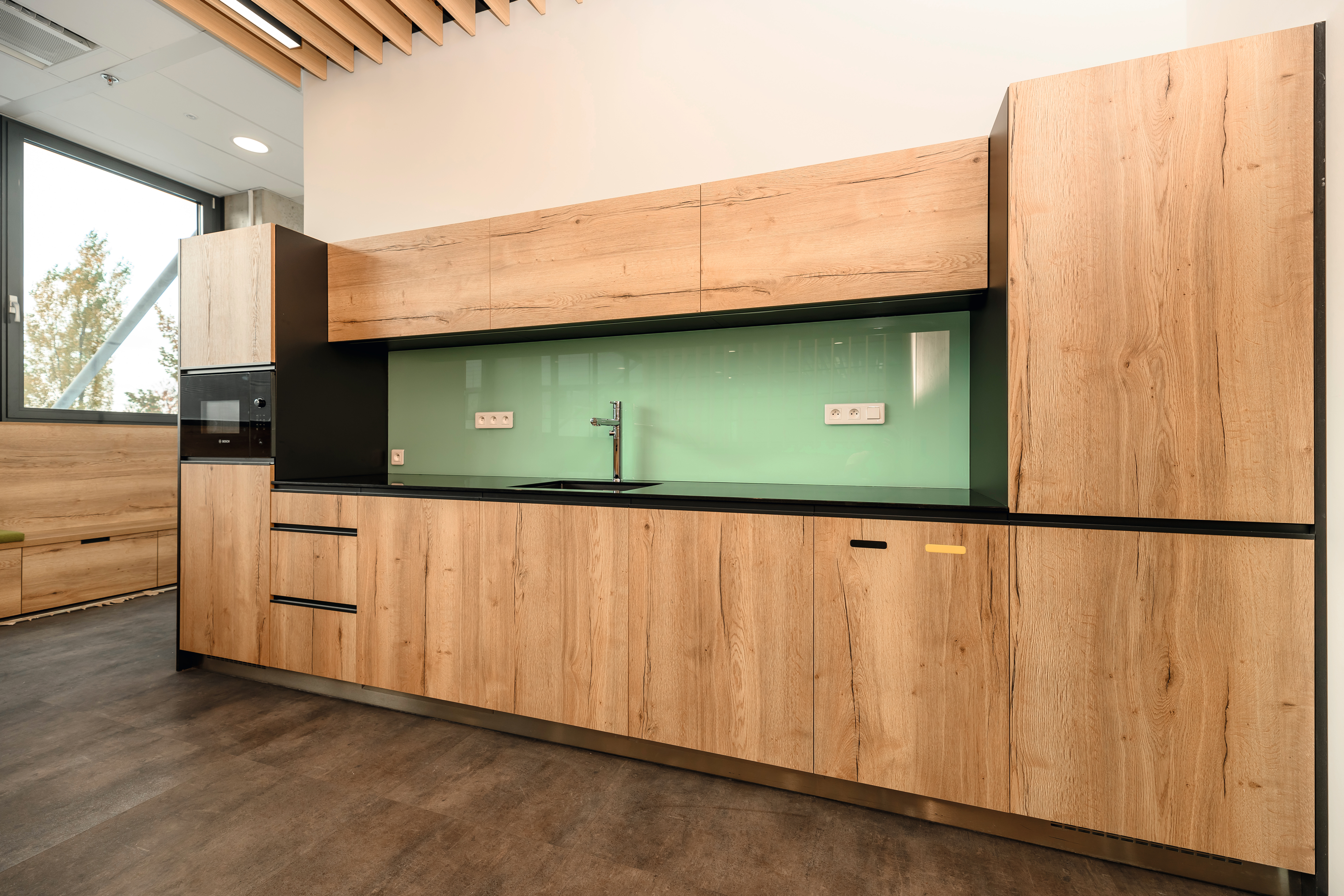 Natural Halifax Oak continues to the kitchen cabinets in the company kitchen for a harmonious design. 