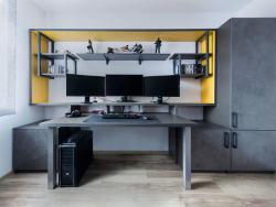 Kancelář je navržena v šedých tónech se žlutými kontrasty.