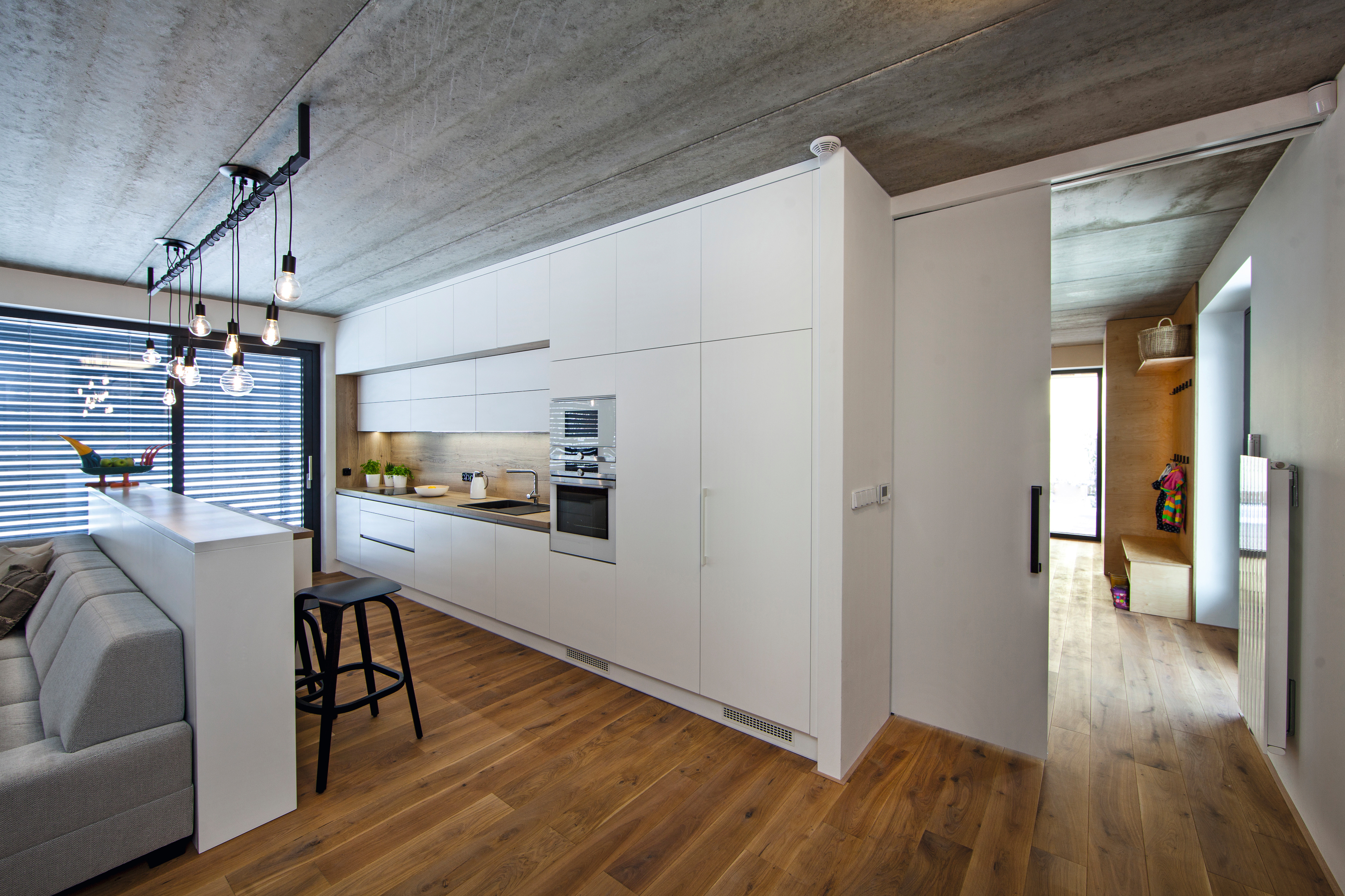 Účelně navržený design domu s dominantní kuchyní, kde dřevo a industriální prvky působí poutavým dojmem.