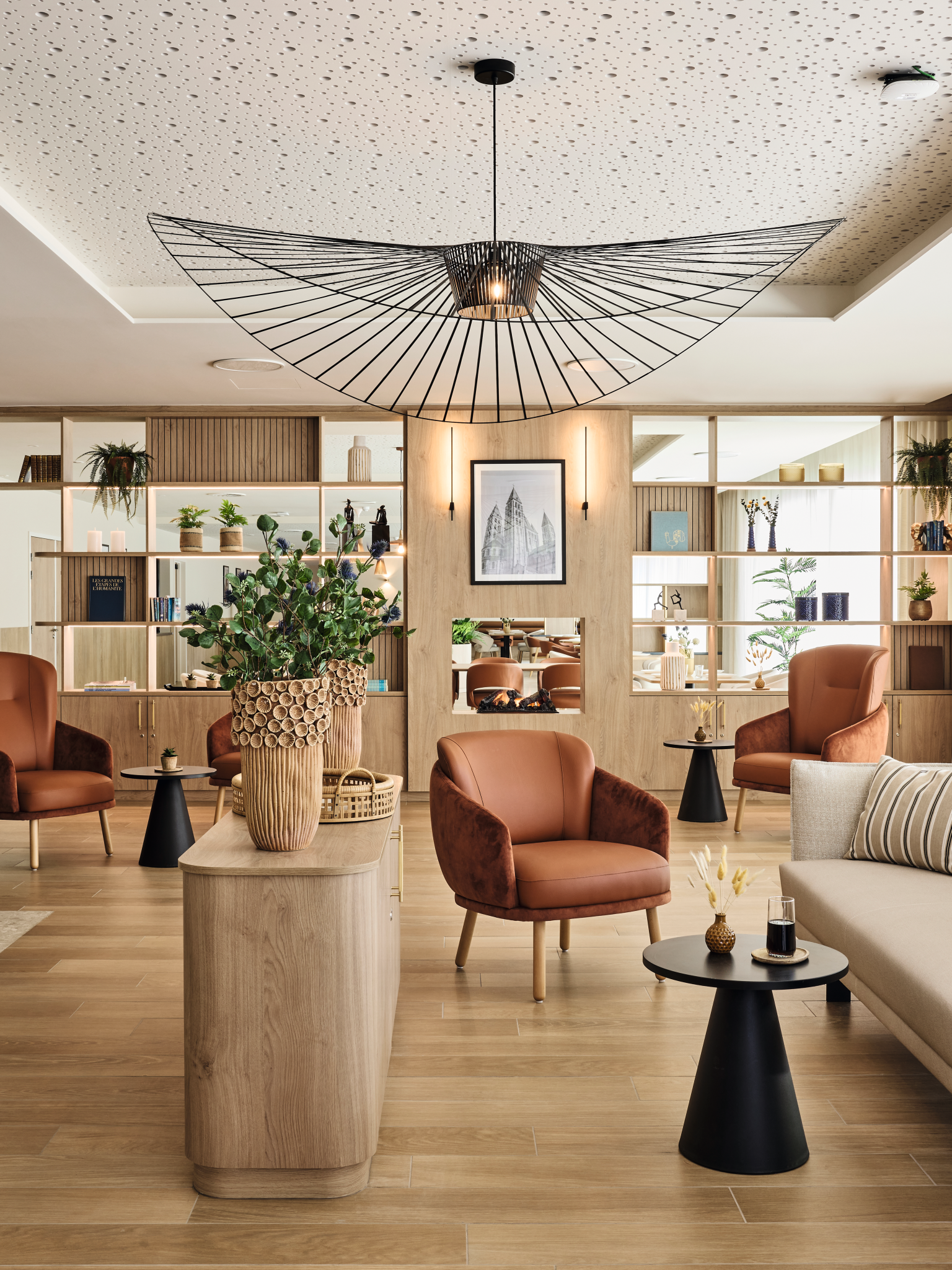 Zona lounge nella casa di riposo con arredi e rivestimenti a parete realizzati in pannelli truciolari nobilitati