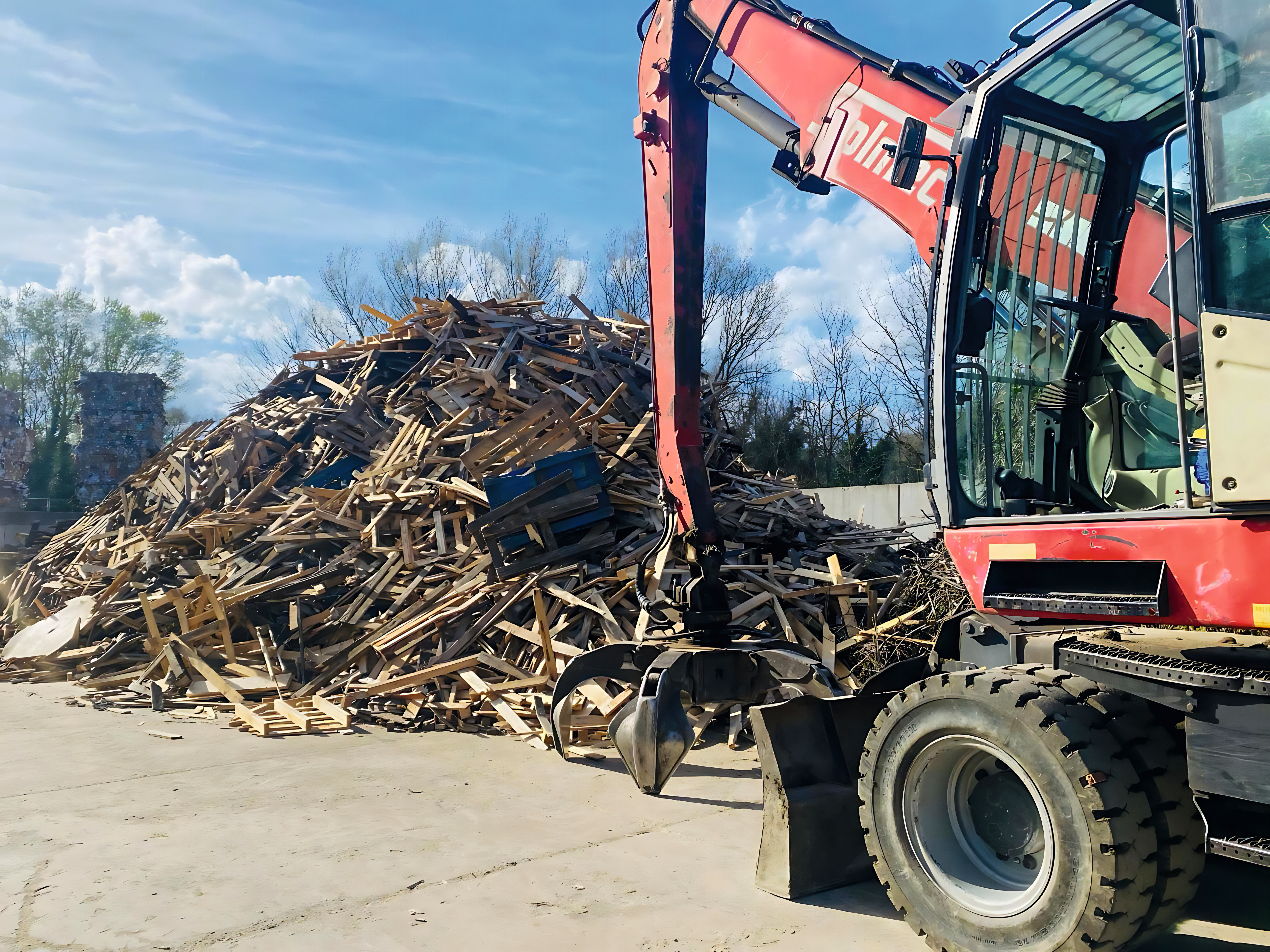 Bois de recyclage et pelleteuse sur le site de collecte de bois de recyclage d'Urbania (Italie)