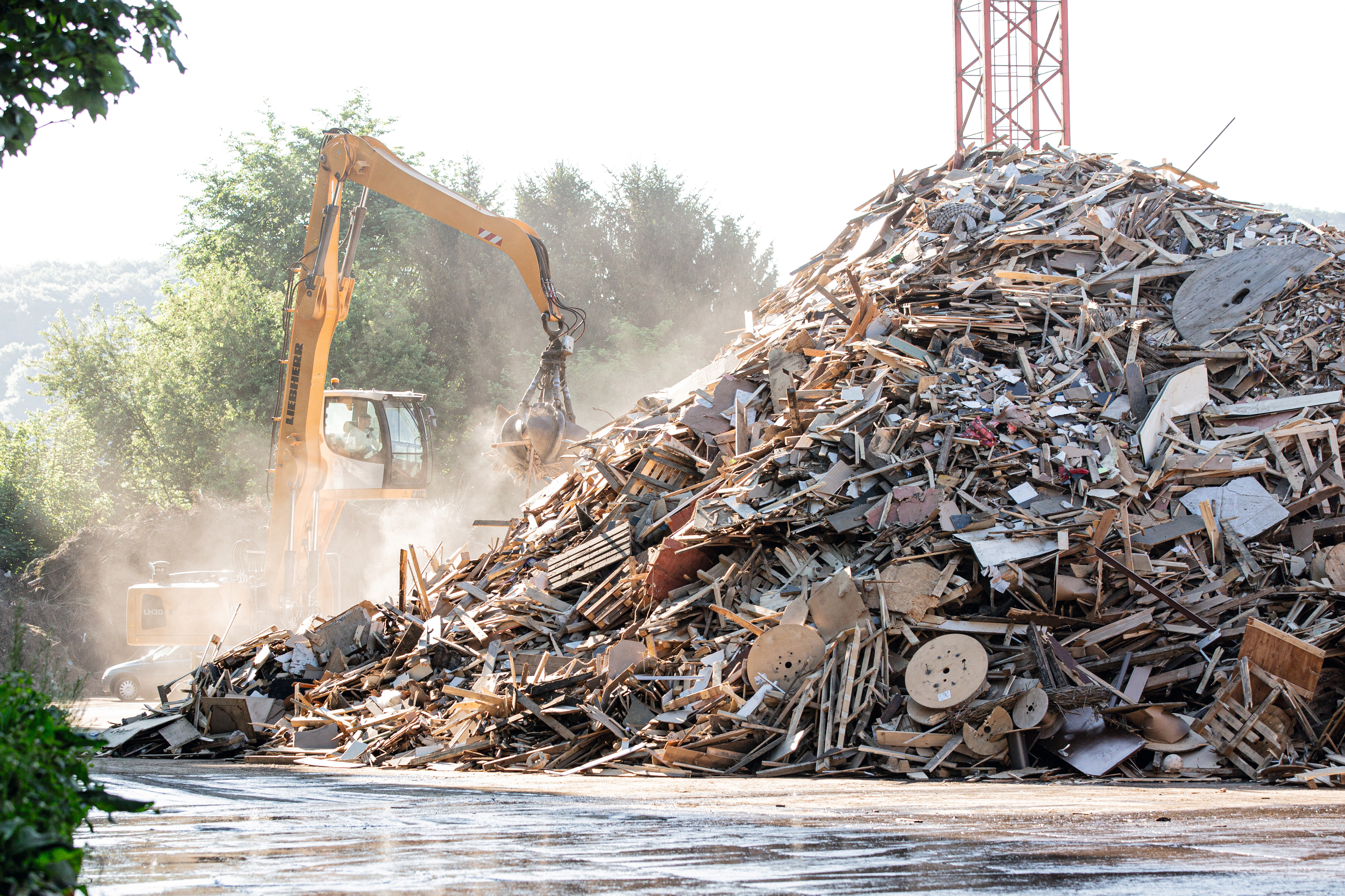 Escavadora movimenta materiais reciclados feitos de madeira