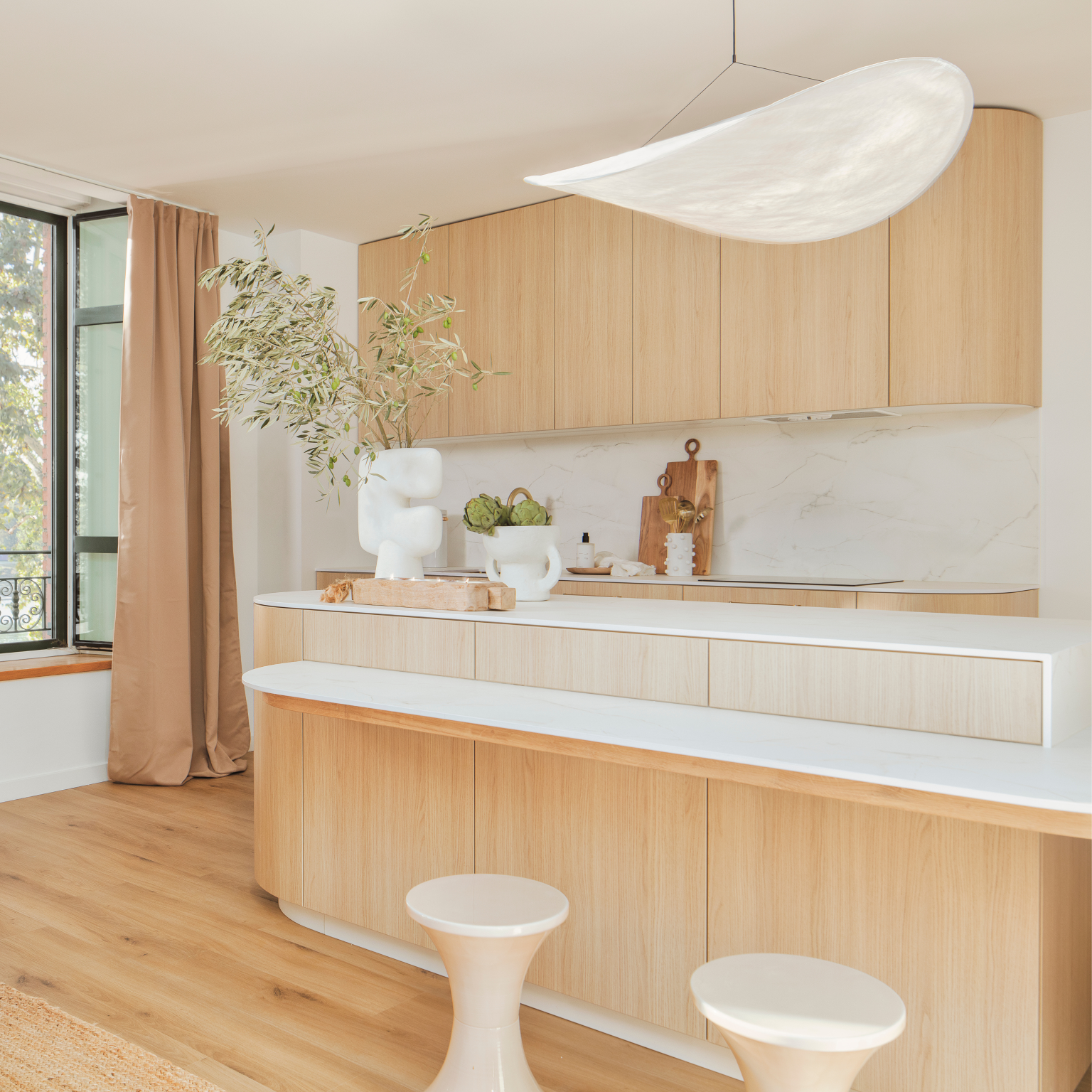 Vue d’angle de la cuisine rénovée du projet Carmes à Toulouse, mettant en valeur les lignes épurées et le décor en chêne clair Vicenza H3157 ST12, dans une ambiance lumineuse et chaleureuse.
