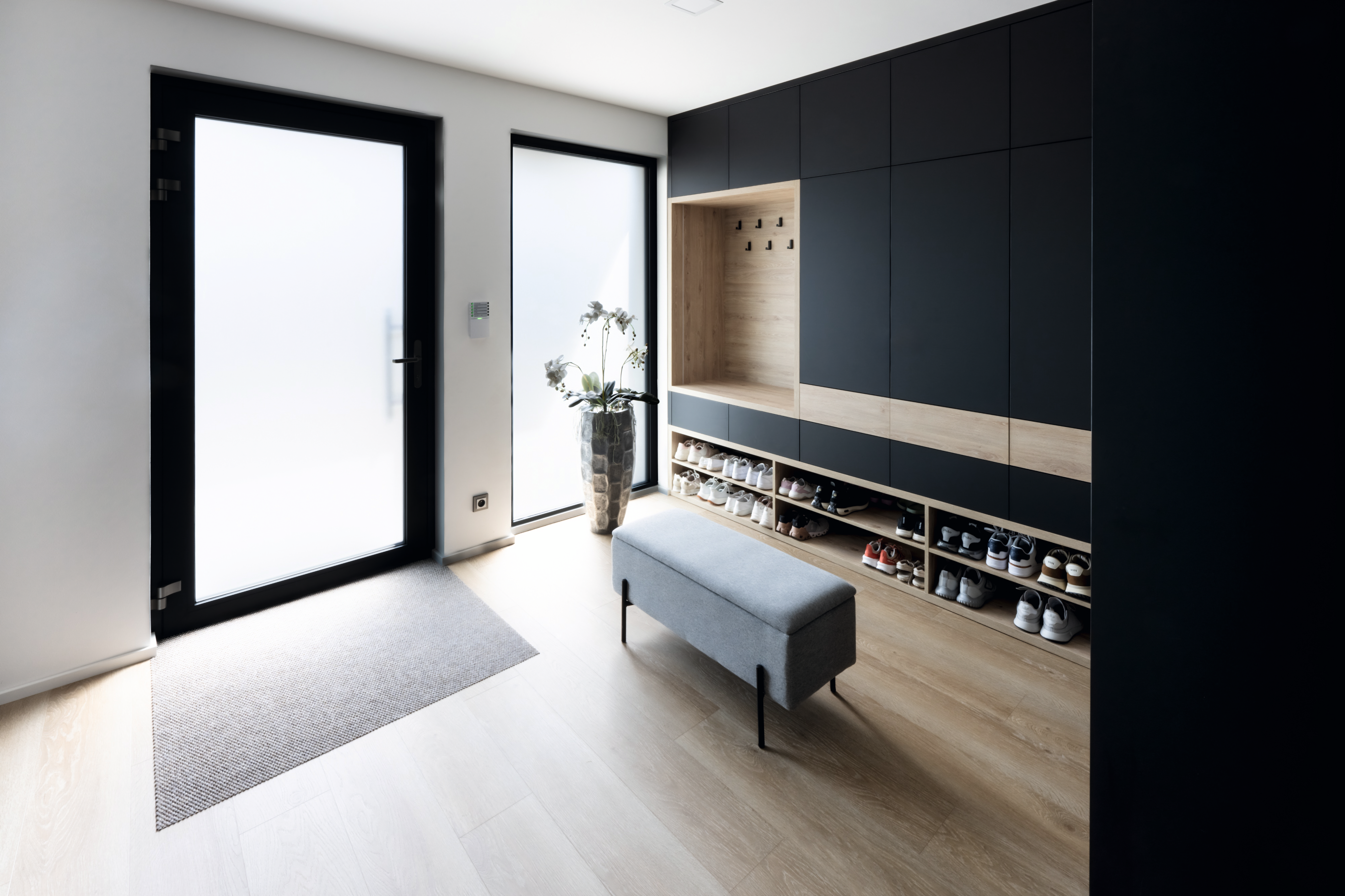 Entrance area with built-in cupboard in matt black and oak reproduction.