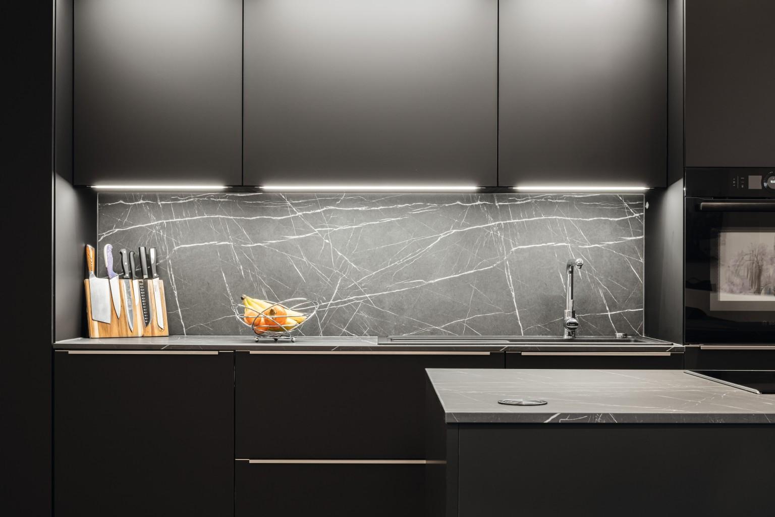 Les touches raffinées de la marbrure claire confèrent du caractère et du charme aux surfaces noires dans le décor U999 PM Noir.