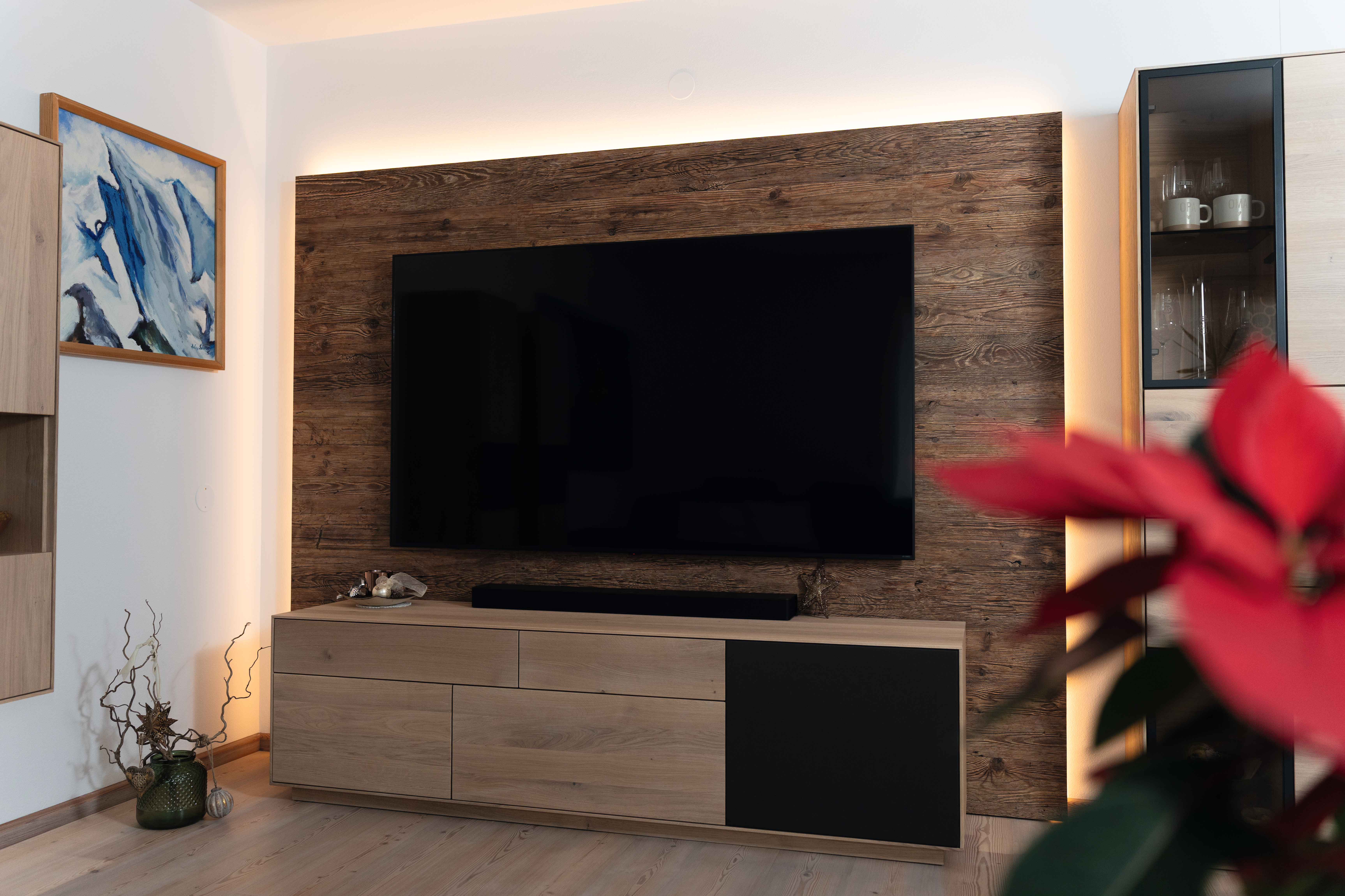 Front view of the OSB wall cladding in the decor Natural Namur Spruce, DO001 with integrated TV and indirect LED lighting. 