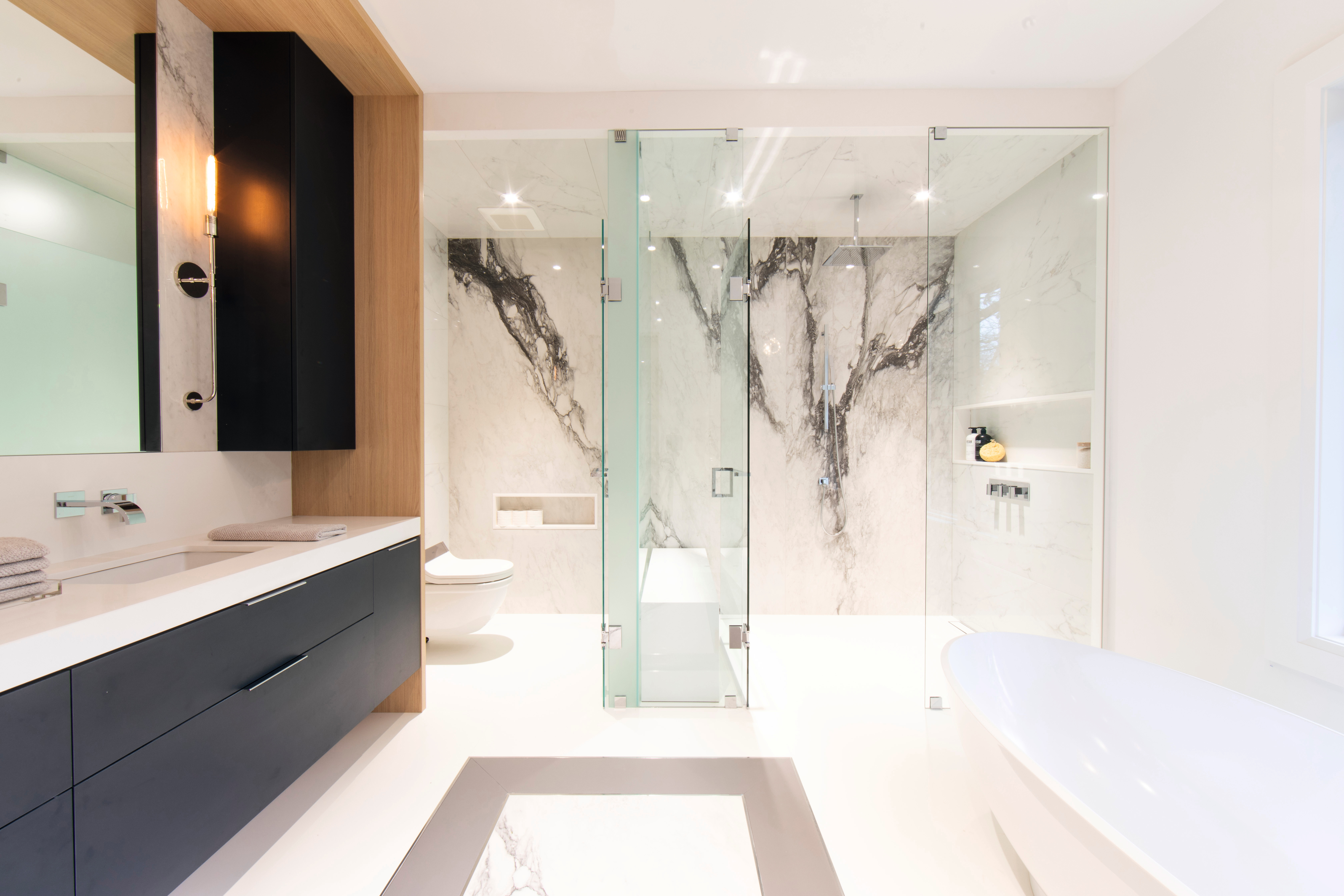 Black accents paired with a light natural wood look and elegant marble transform the bathroom into an oasis of well-being.