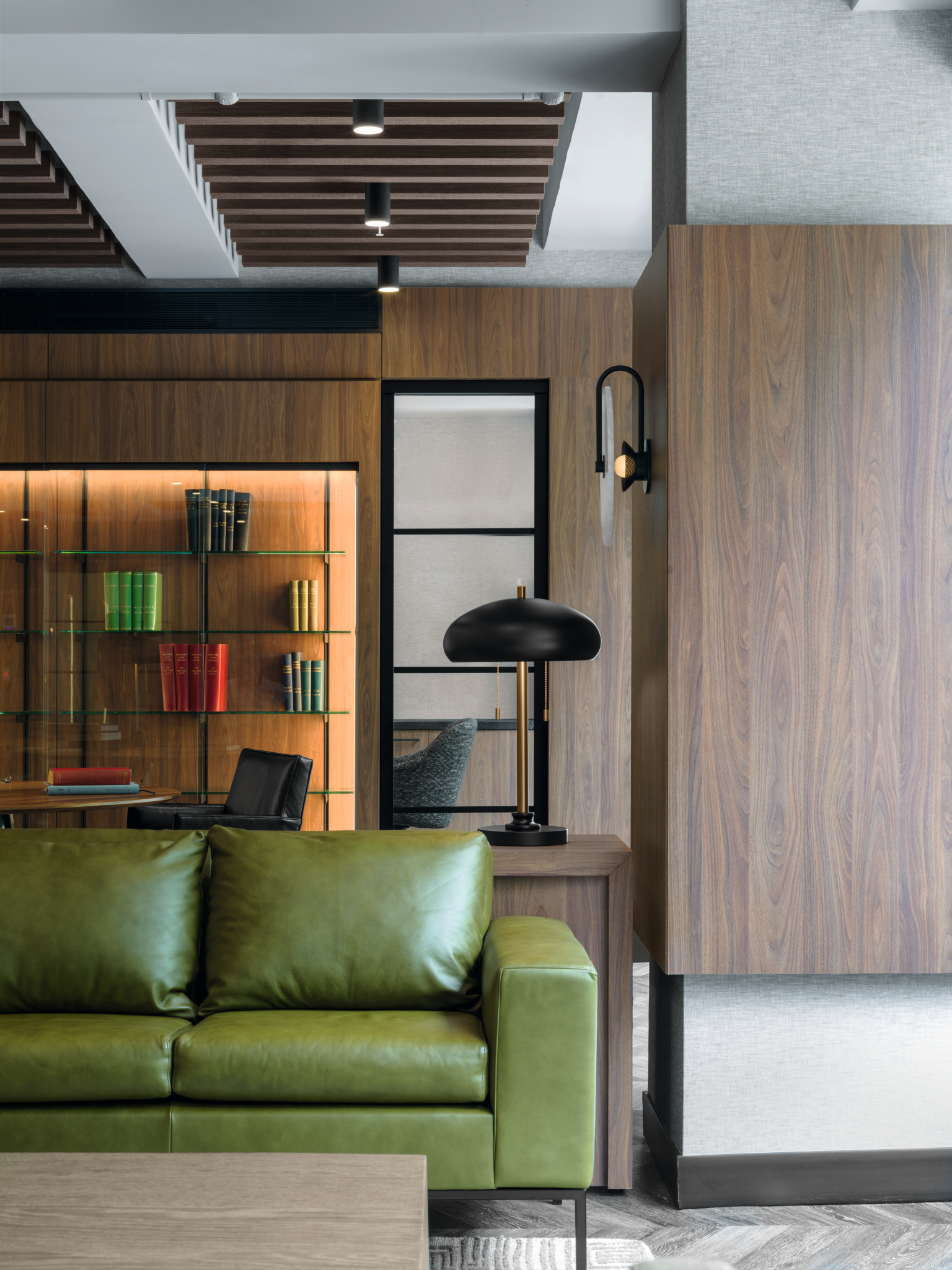 H3791 ST12 Auburn Carini Walnut millwork frames the display shelving and architectural openings, bringing depth and balance to the lounge setting. 