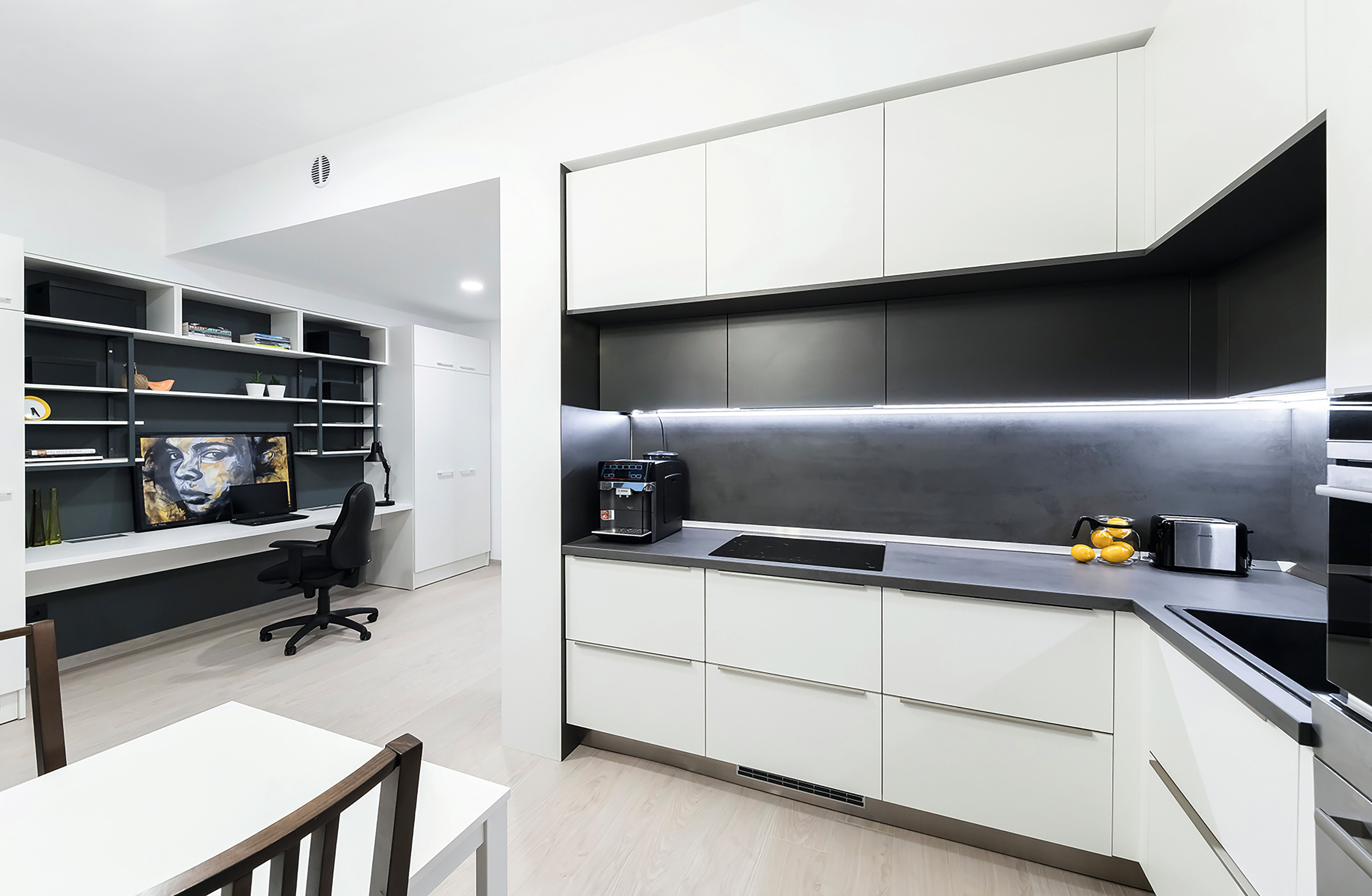 The bright white kitchen was created with W1000 Premium White, while U963 ST9 Diamond Grey on the lower cabinets and F641 ST10 Chromix Anthracite on the countertop provide contrast and depth.