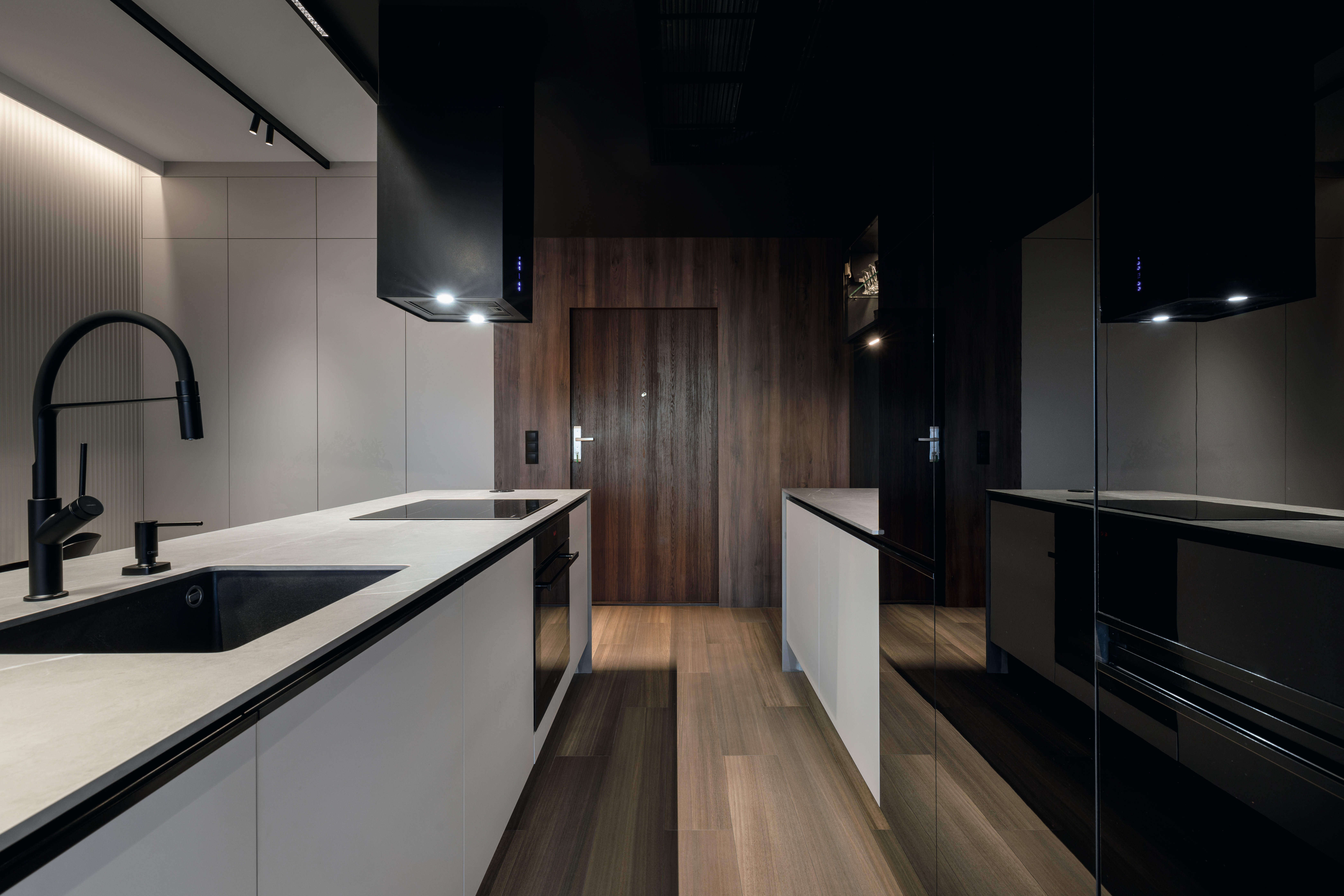 The U999 PG Black of the kitchen front adds more depth to the room. U708 PM Light Grey was used for the cabinet fronts of the kitchen island. The entrance door features the H3702 ST10 décor, and the wall cladding the H1714 ST19 Lincoln Walnut decor.