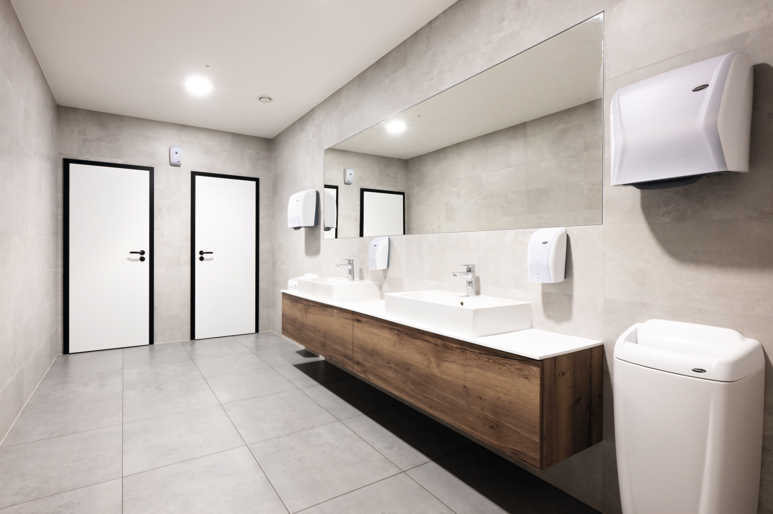 Servizi igienici con un ampio specchio a parete e mobile lavabo effetto legno
