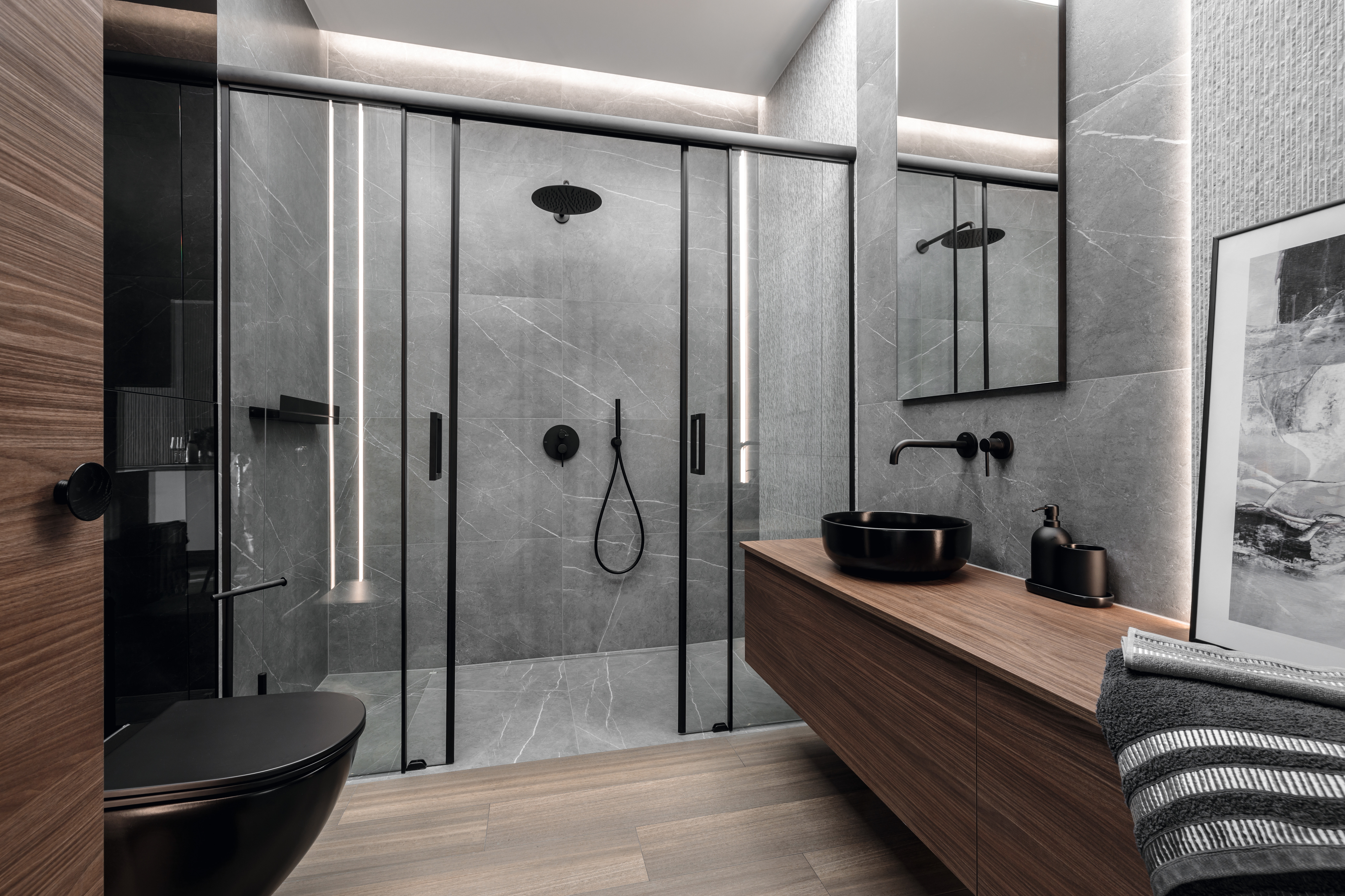 In the bathroom, the warm wood tone of H1714 ST19 Lincoln Walnut harmonises with the grey tiles. 