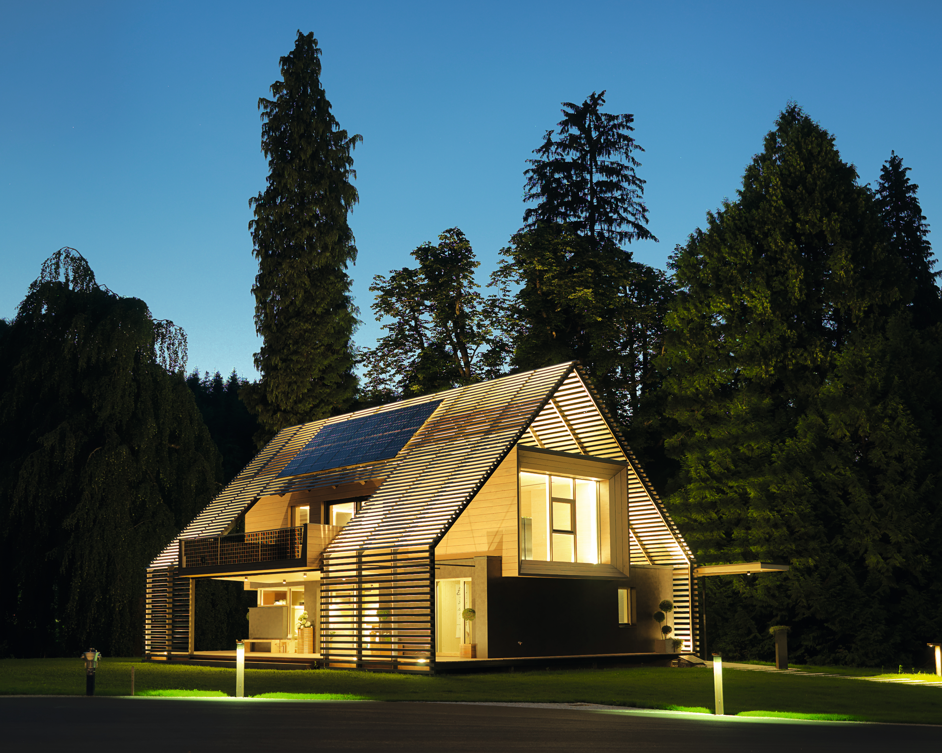 Energieeffizientes Passivhaus mit Solarpaneelen und moderner Holzfassade.