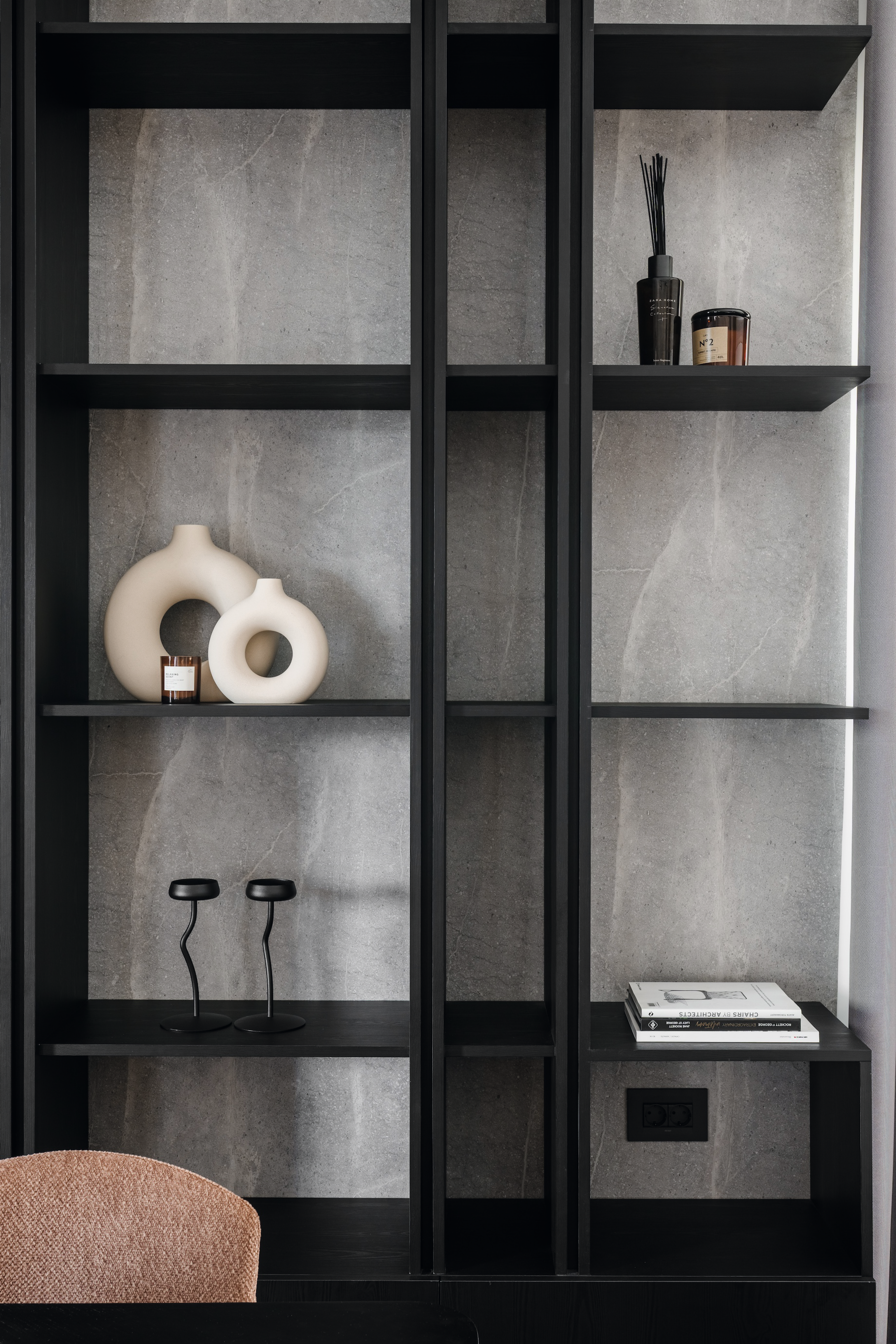 Boekenplanken in de woonkamer met een zwart en grijs marmerdecor.