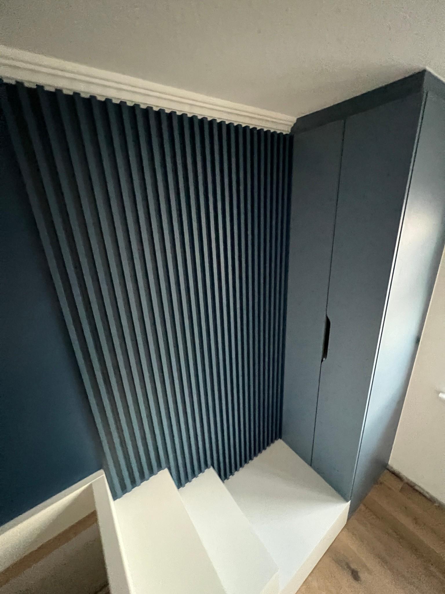 El armario con la pared de listones en U504 ST9 Tyrolean Blue crea un ambiente acogedor. 