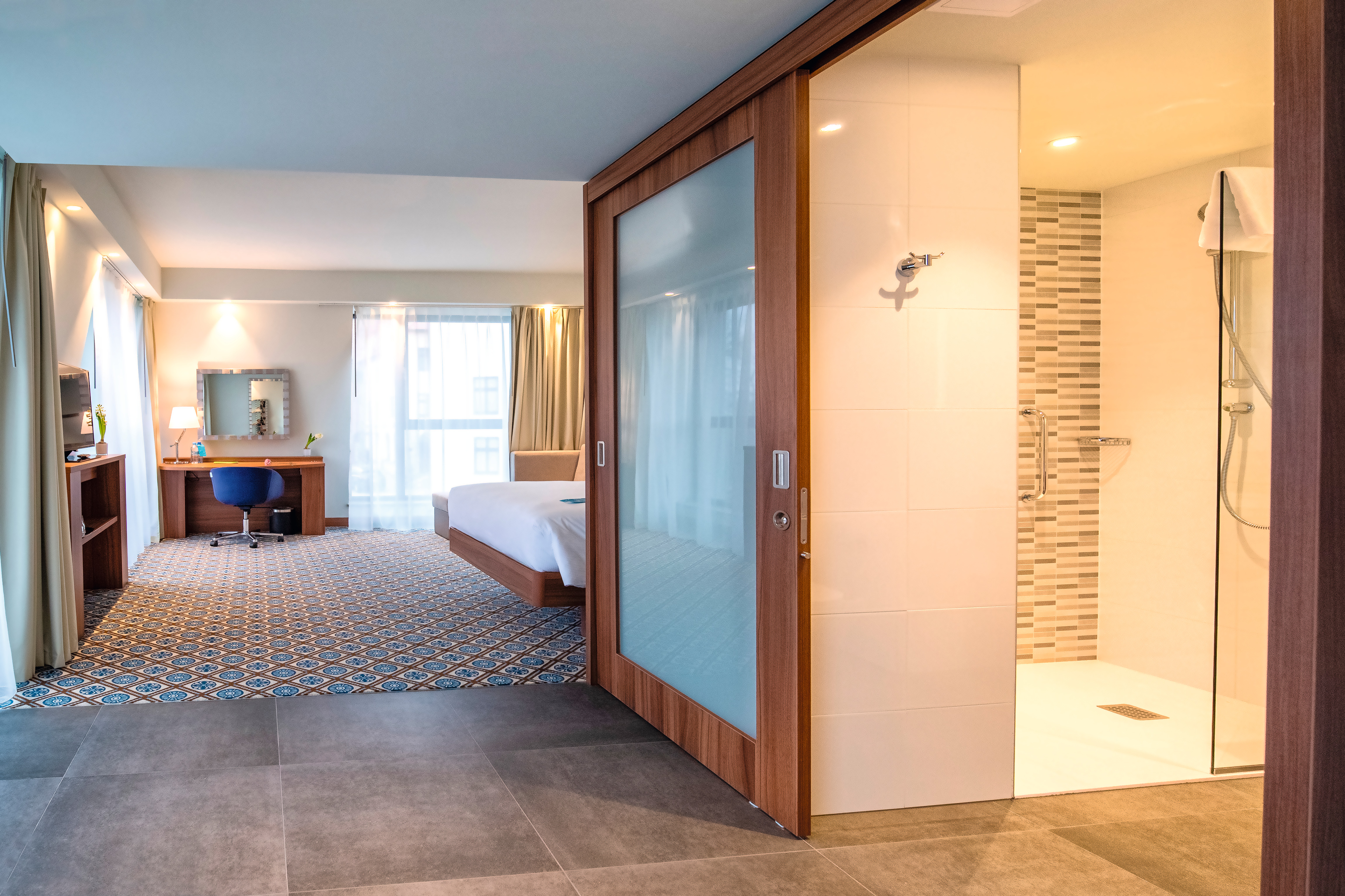 O décor H3734 ST9 Nogueira de Borgonha natural é utilizado nos quartos do hotel para criar um visual moderno.